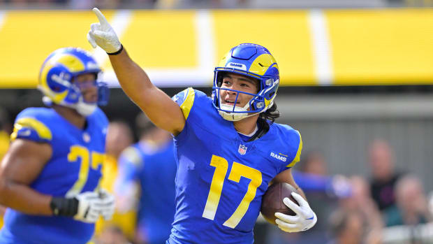 Puka Nacua points a finger in the air after scoring a touchdown, holding the ball in his other hand